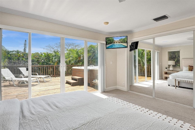 carpeted bedroom with multiple windows, visible vents, crown molding, and access to exterior