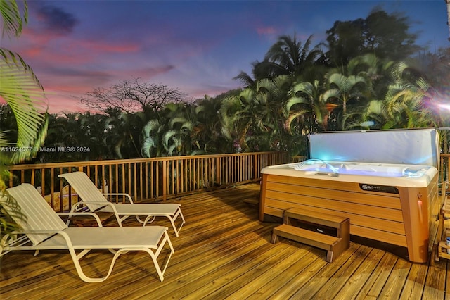 deck at dusk with a hot tub