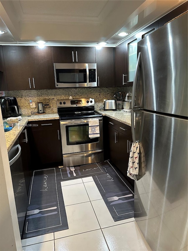 kitchen with dark brown cabinetry, tasteful backsplash, stainless steel appliances, and ornamental molding