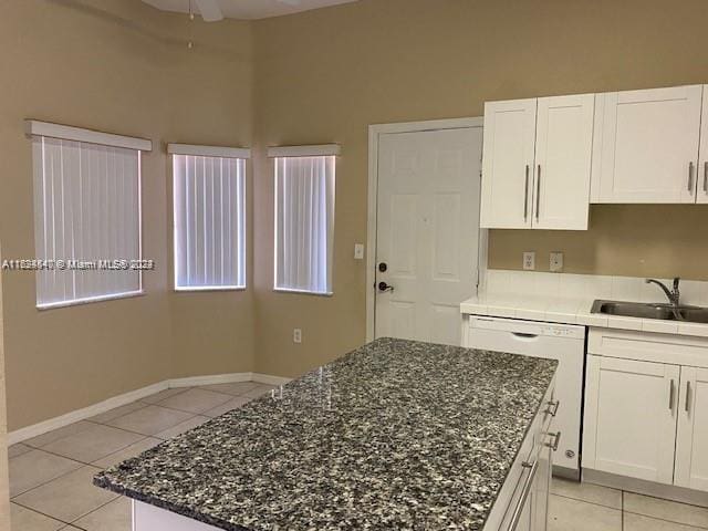 kitchen featuring white cabinets, sink, light tile patterned floors, a kitchen island, and ceiling fan