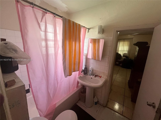 full bathroom featuring sink, tile patterned floors, shower / bath combination with curtain, toilet, and decorative backsplash