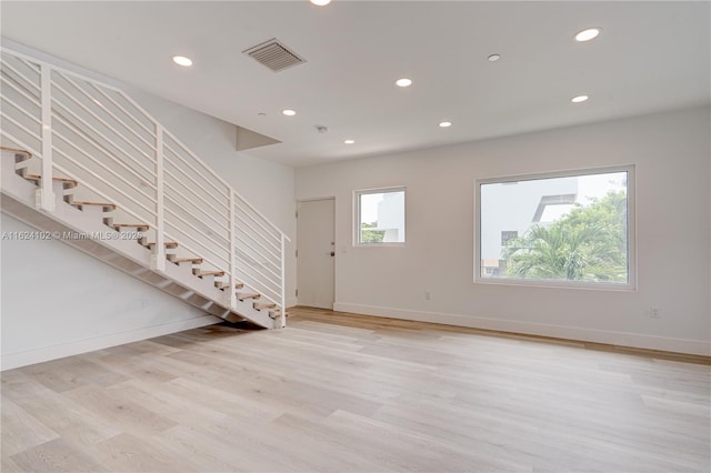 unfurnished room featuring recessed lighting, visible vents, baseboards, stairs, and light wood finished floors