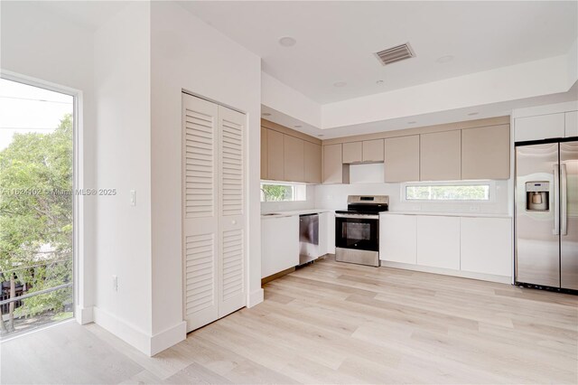 laundry room featuring stacked washer and dryer and light wood-type flooring