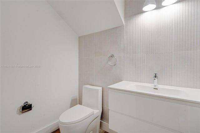 bathroom with vanity, vaulted ceiling, and toilet