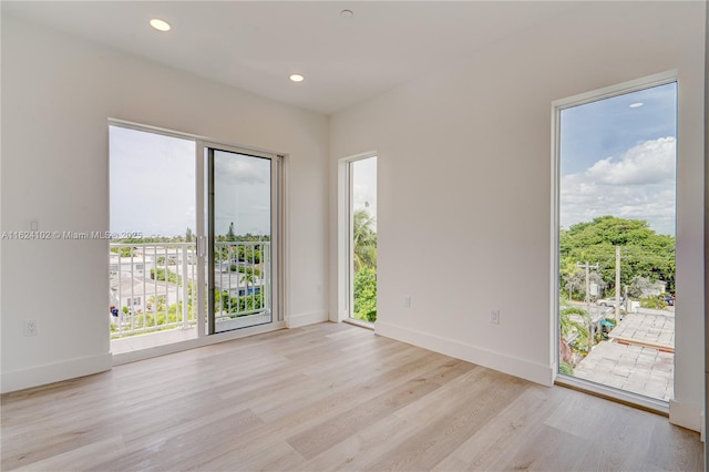 unfurnished room featuring light wood finished floors, recessed lighting, and baseboards