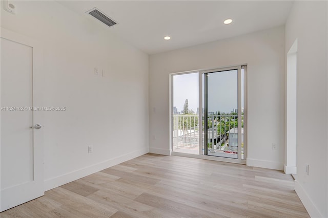 spare room with light wood finished floors, recessed lighting, visible vents, and baseboards