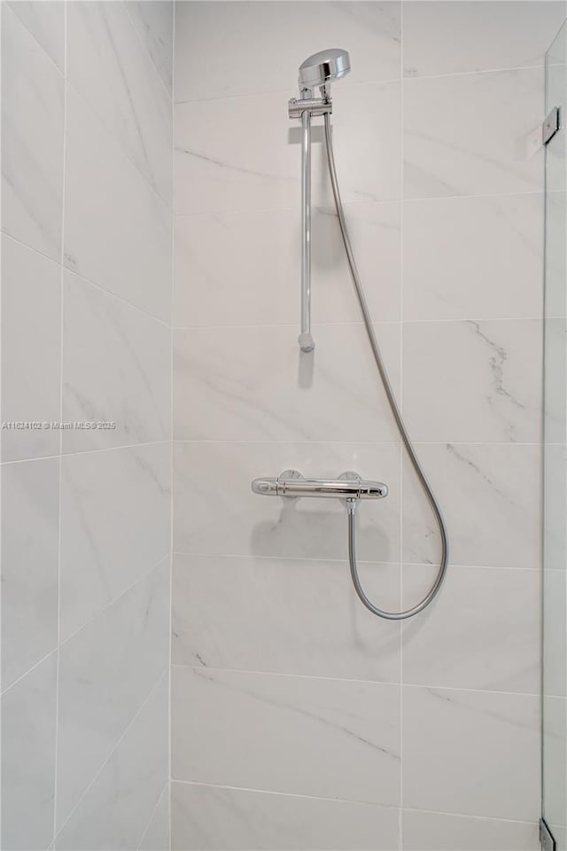 interior details with a tile shower