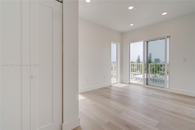 unfurnished room with light wood-style floors, baseboards, and recessed lighting