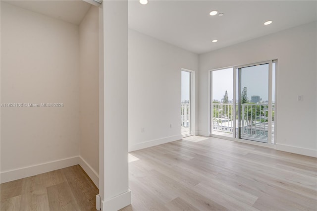 spare room with light wood finished floors, baseboards, and recessed lighting