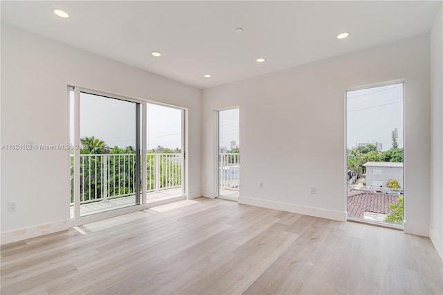 unfurnished room with recessed lighting, baseboards, and light wood finished floors