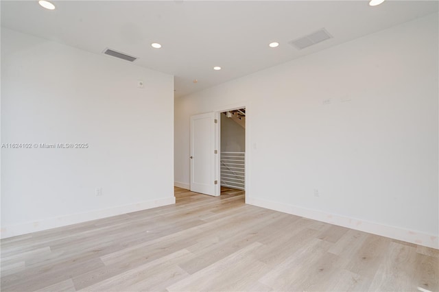 unfurnished room with recessed lighting, baseboards, visible vents, and light wood finished floors