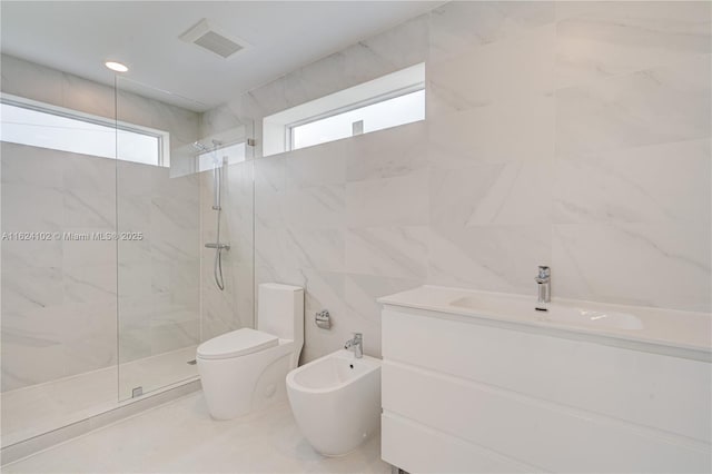 bathroom featuring tile walls, a marble finish shower, visible vents, toilet, and a bidet