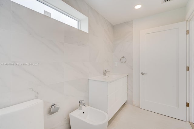 bathroom featuring recessed lighting, a bidet, tile walls, and vanity