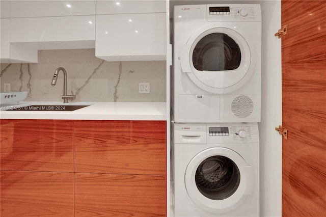 washroom featuring sink and stacked washing maching and dryer