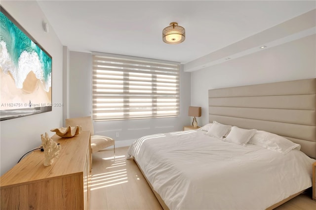 bedroom with multiple windows and light hardwood / wood-style floors