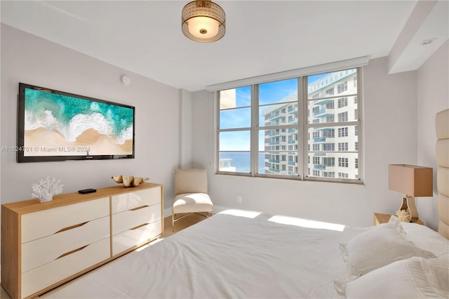 bedroom featuring a water view and multiple windows