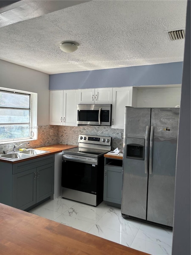 kitchen featuring white cabinets, sink, gray cabinetry, and stainless steel appliances