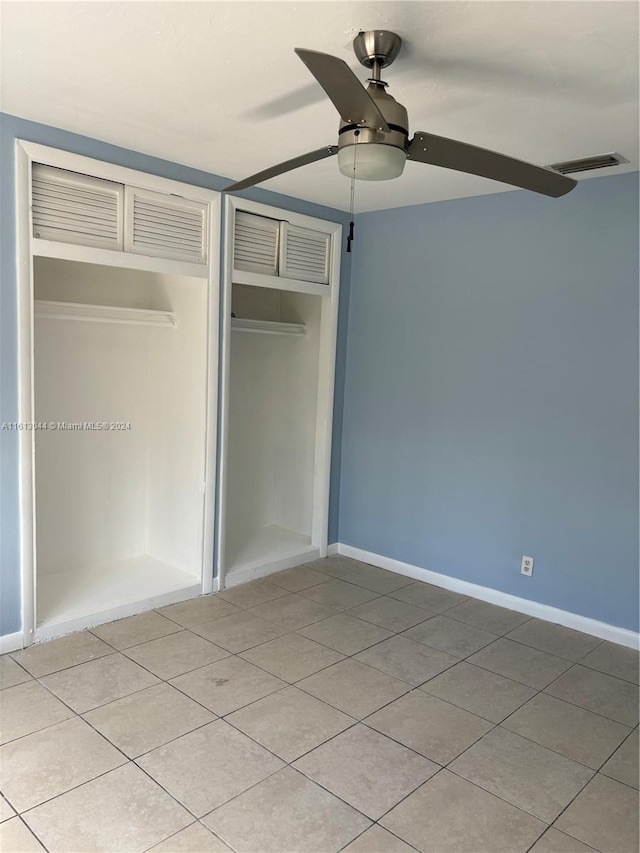 unfurnished bedroom with light tile patterned floors, a closet, and ceiling fan