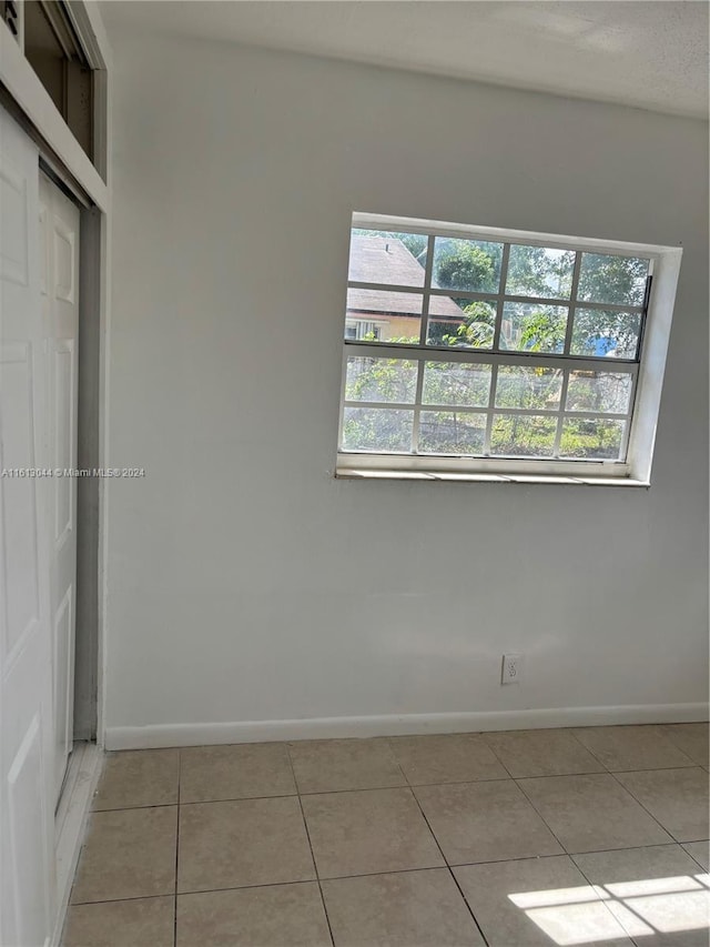 empty room with plenty of natural light and light tile patterned flooring