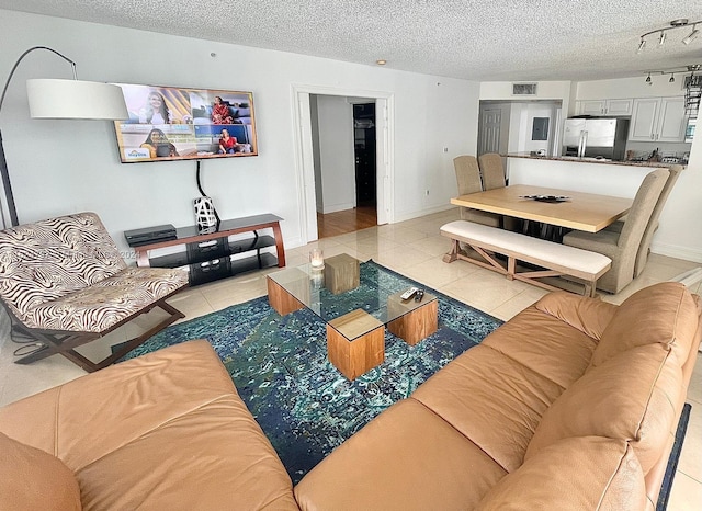 tiled living room featuring a textured ceiling