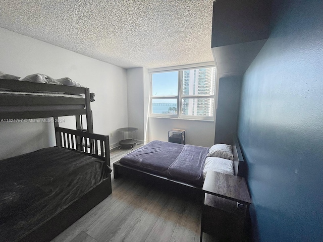 bedroom with a textured ceiling and hardwood / wood-style floors