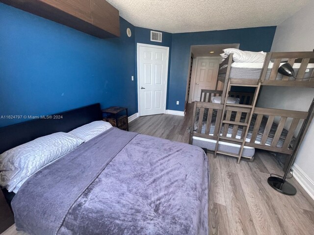 bedroom featuring wood-type flooring and a textured ceiling