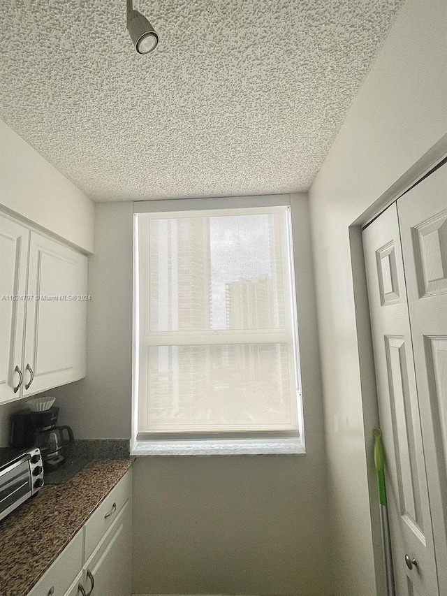 kitchen with white cabinets and a textured ceiling