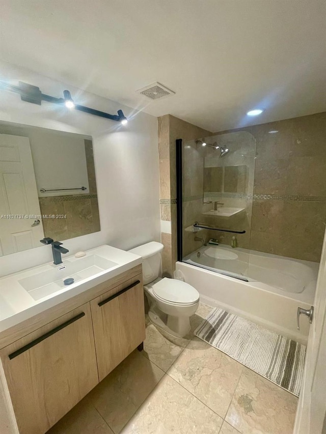 full bathroom with tiled shower / bath combo, vanity, and toilet