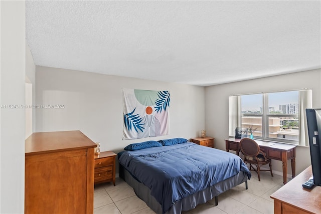 bedroom with light tile patterned floors and a textured ceiling