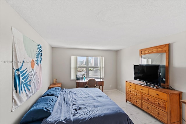 bedroom featuring light tile patterned flooring and a textured ceiling