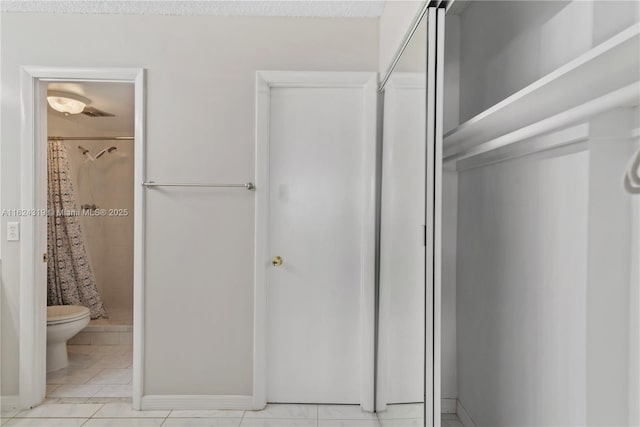 bathroom with tile patterned flooring, a shower with curtain, and toilet