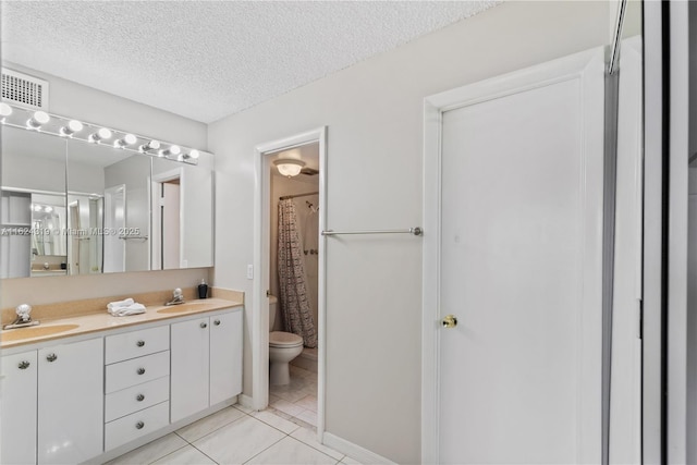 bathroom featuring vanity, a shower with curtain, tile patterned flooring, toilet, and a textured ceiling