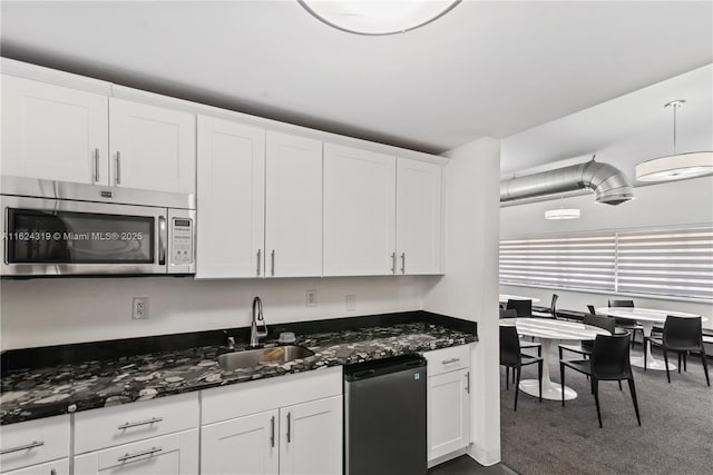 kitchen featuring white cabinets, sink, appliances with stainless steel finishes, and dark stone counters