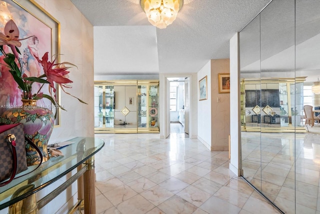 foyer featuring a textured ceiling, a notable chandelier, and lofted ceiling