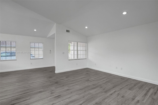 spare room featuring hardwood / wood-style flooring, lofted ceiling, and a healthy amount of sunlight