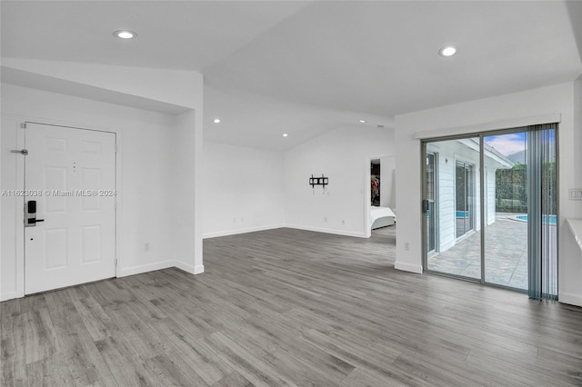 spare room featuring lofted ceiling and wood-type flooring