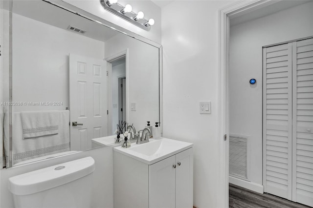 bathroom with vanity, wood-type flooring, and toilet