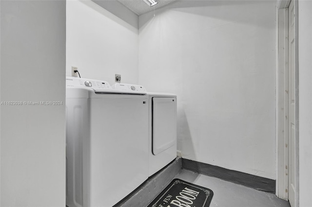 laundry room featuring washer and clothes dryer and a textured ceiling