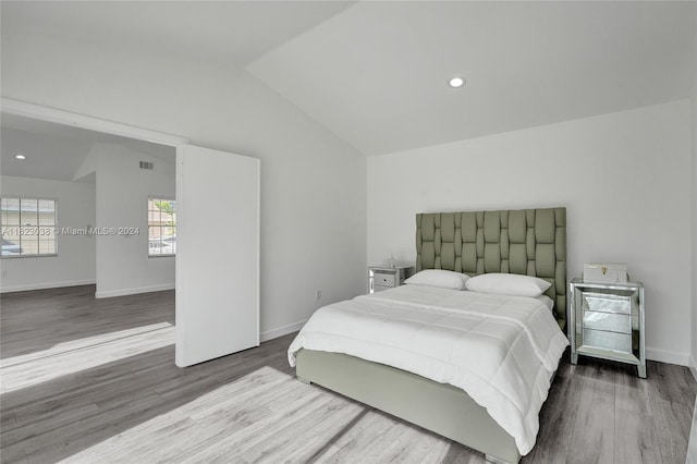 bedroom featuring lofted ceiling and hardwood / wood-style flooring