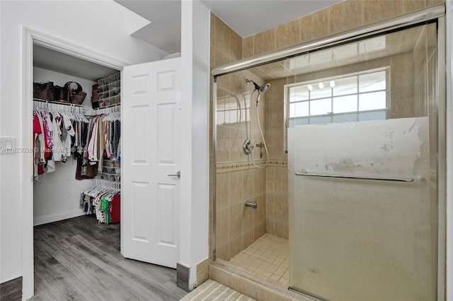 bathroom with hardwood / wood-style flooring and an enclosed shower