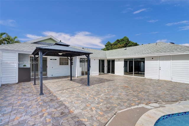 rear view of property featuring a gazebo and a patio area