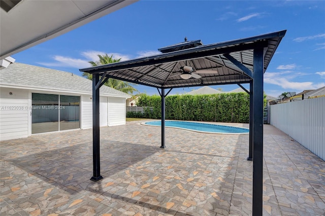 view of swimming pool featuring a patio and ceiling fan