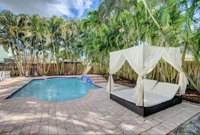 view of pool featuring pool water feature and a patio area