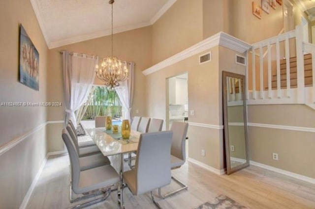 dining room featuring high vaulted ceiling, a chandelier, light hardwood / wood-style flooring, and ornamental molding