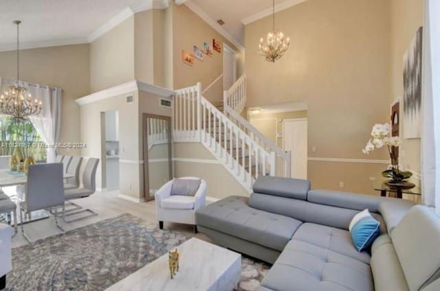 living room with an inviting chandelier, high vaulted ceiling, and crown molding