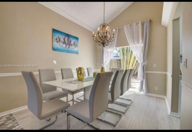 dining space with ornamental molding, an inviting chandelier, lofted ceiling, and light hardwood / wood-style floors