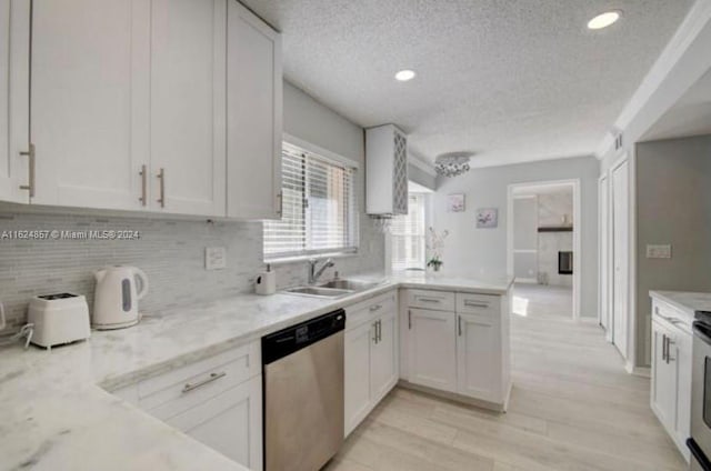 kitchen with white cabinetry, light wood-type flooring, sink, dishwasher, and a textured ceiling