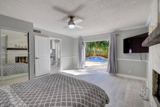 bedroom featuring hardwood / wood-style floors, a textured ceiling, ceiling fan, and access to exterior