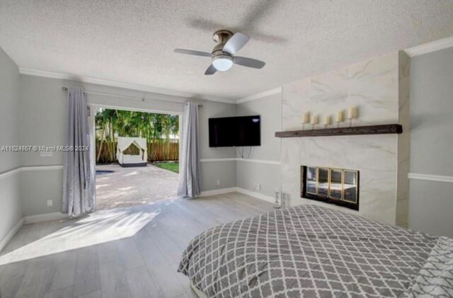 unfurnished bedroom featuring ceiling fan, crown molding, a premium fireplace, and a textured ceiling