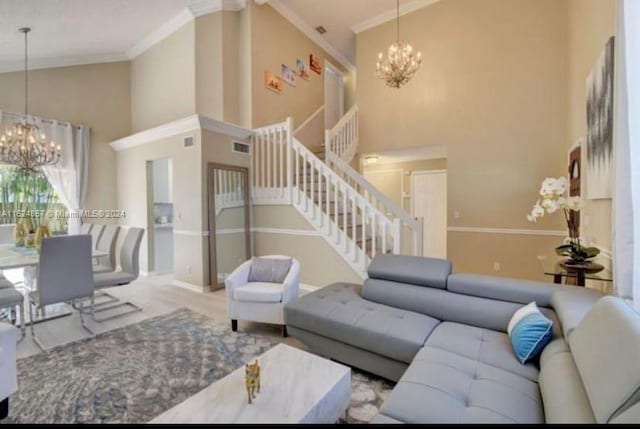 living room with ornamental molding, an inviting chandelier, and high vaulted ceiling